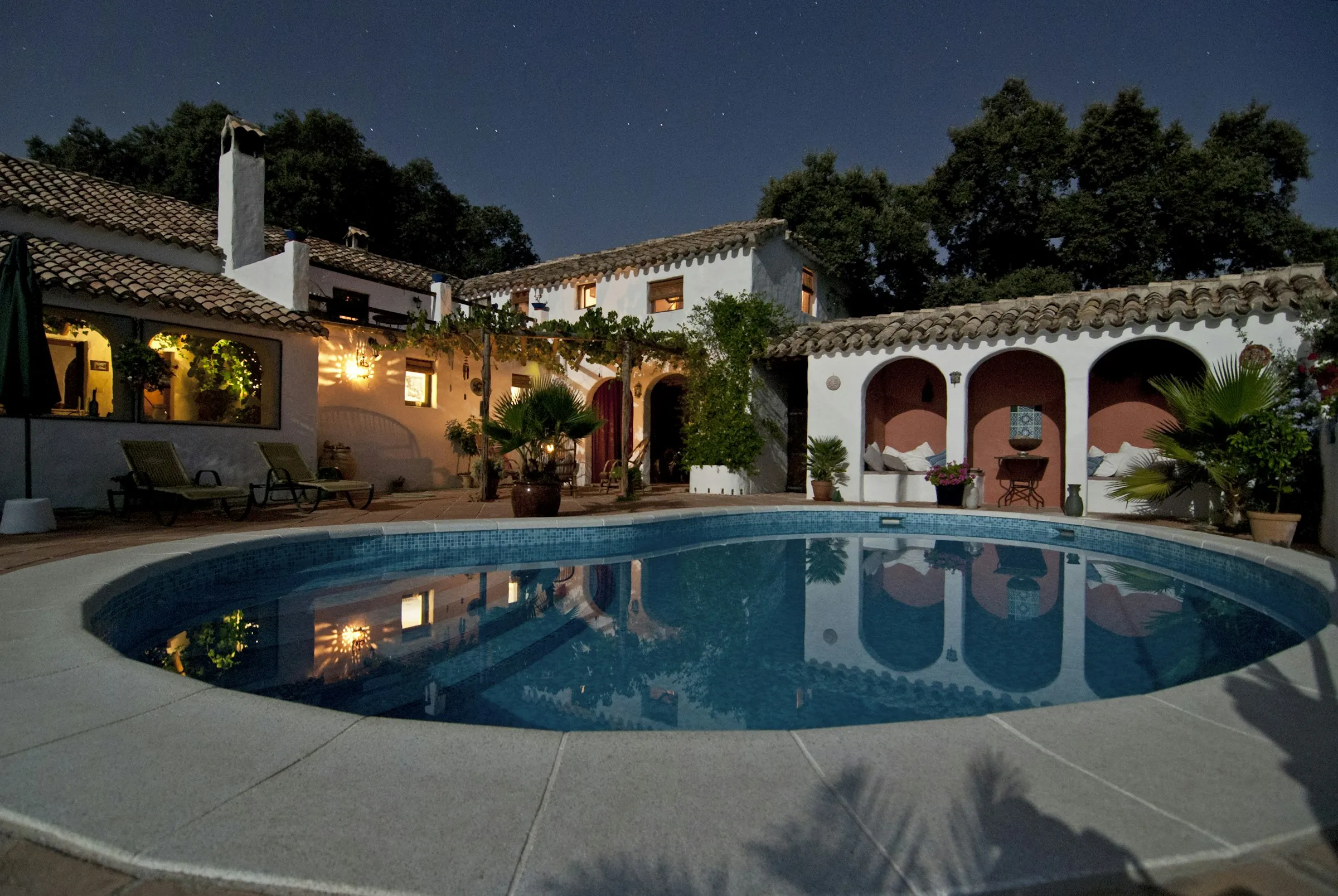 A waterfront villa and pool glowing at dusk