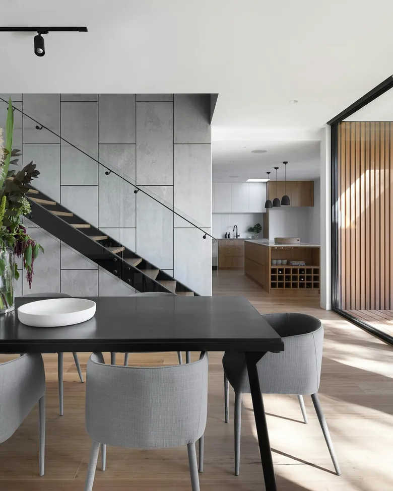 Dining area beside a floating staircase